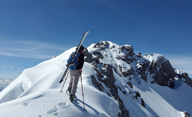 Een toerskiër beklimt een berg.