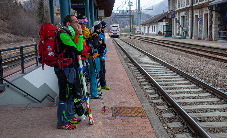 Skiërs wachten op het perron op de trein.